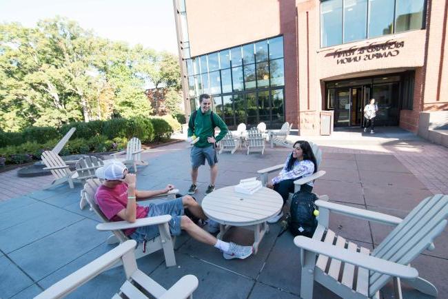 Students sit outside on a sunny day on campus.